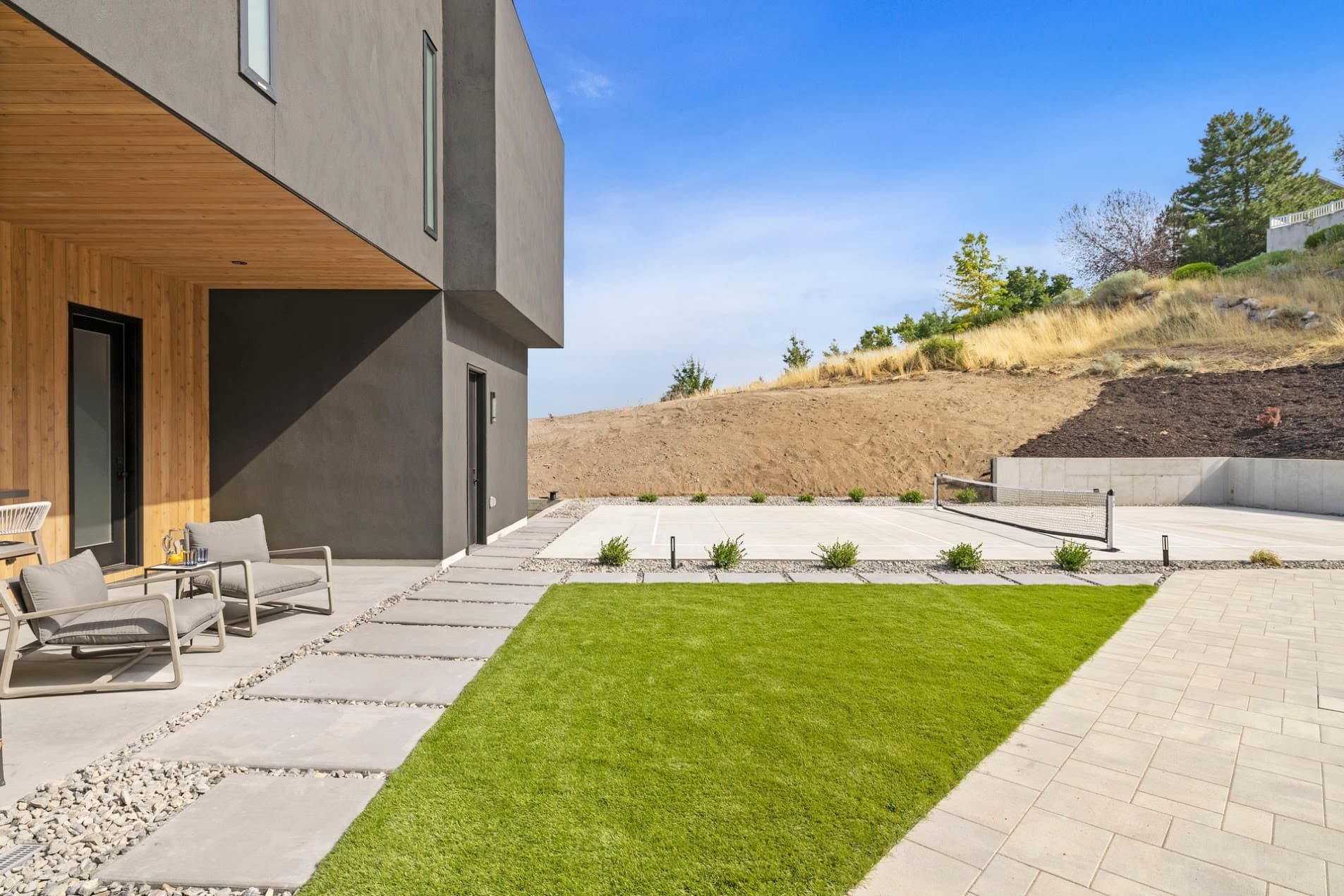 Renovated backyard with sport court, turf, and covered patio