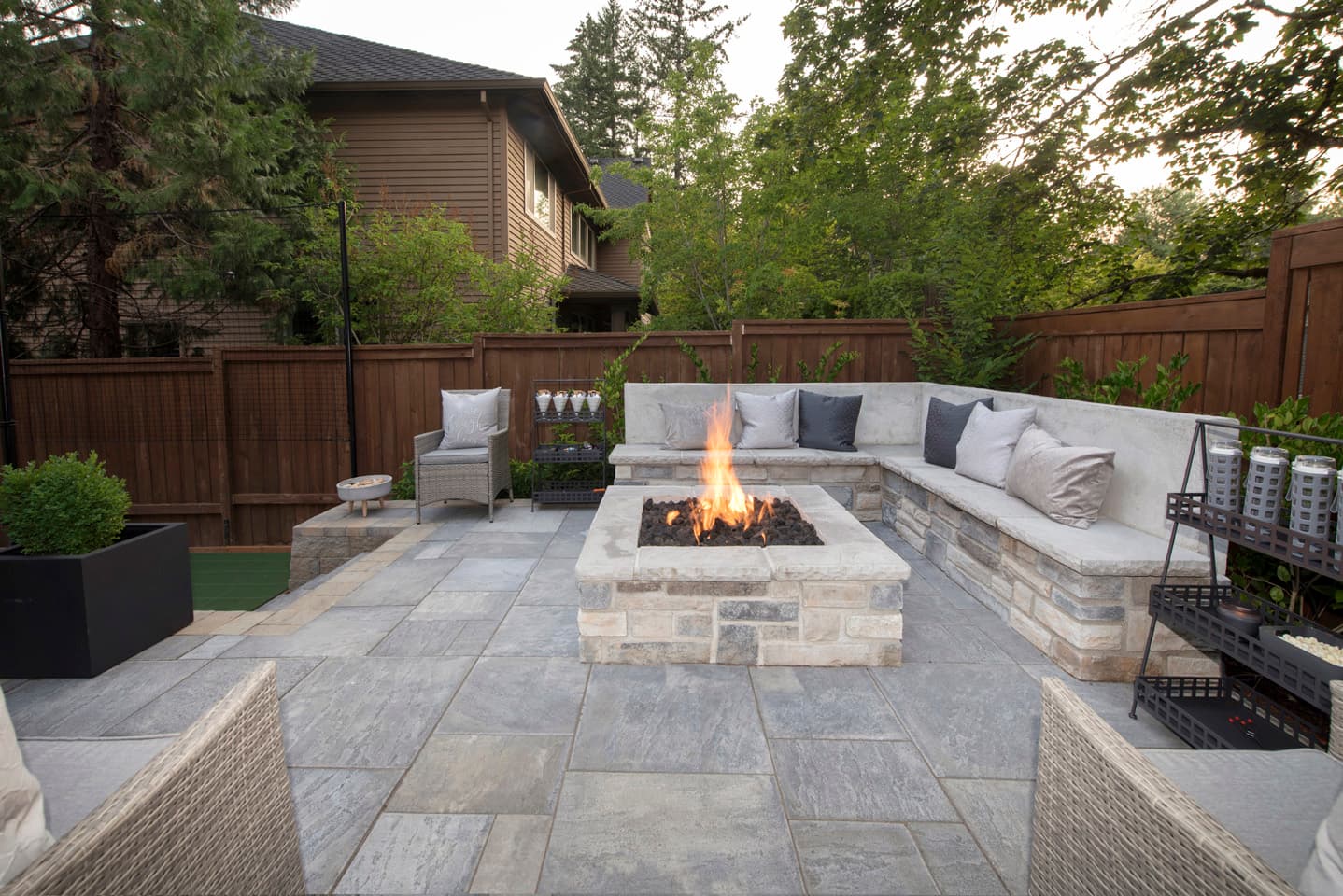 Stone fire pit patio with built-in seating at dusk